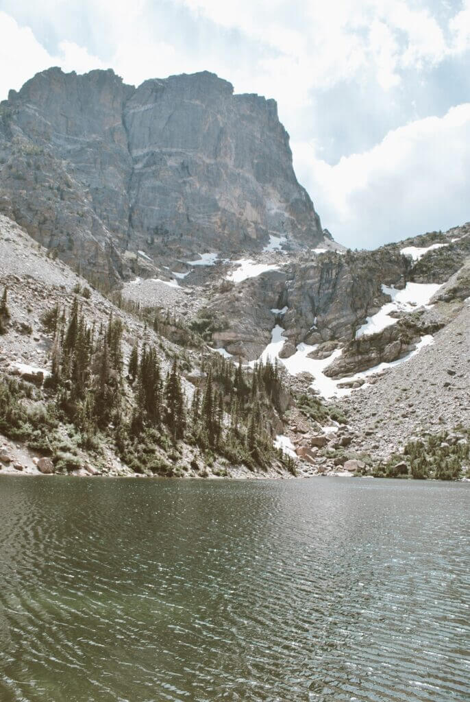 Mountains towering over the crystal clear Emerald Lake in rmnp