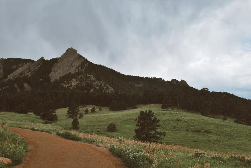 The Flatirons in the distance of Boulder, CO covered in trees