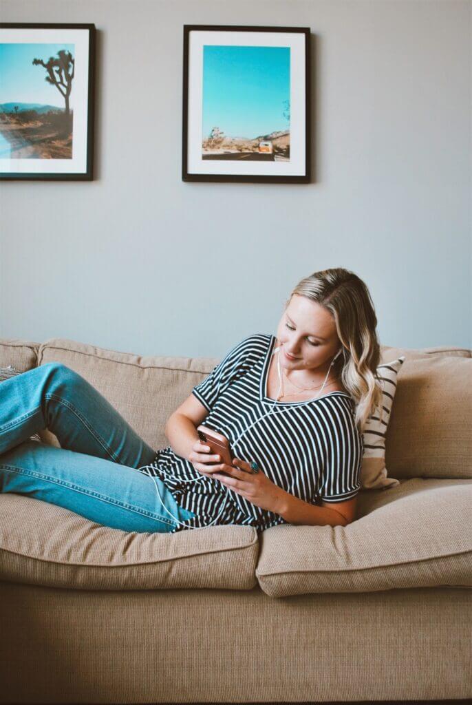 Blonde on the couch thinking what podcast should I listen to?