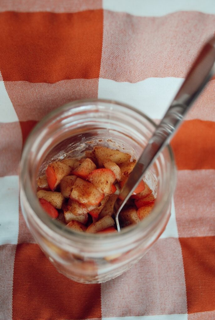 Mason jar full of pudding with a delicious warm apple topping