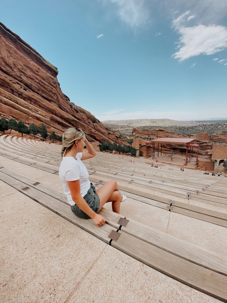 Woman sitting at an empty red rocks theater in 2020